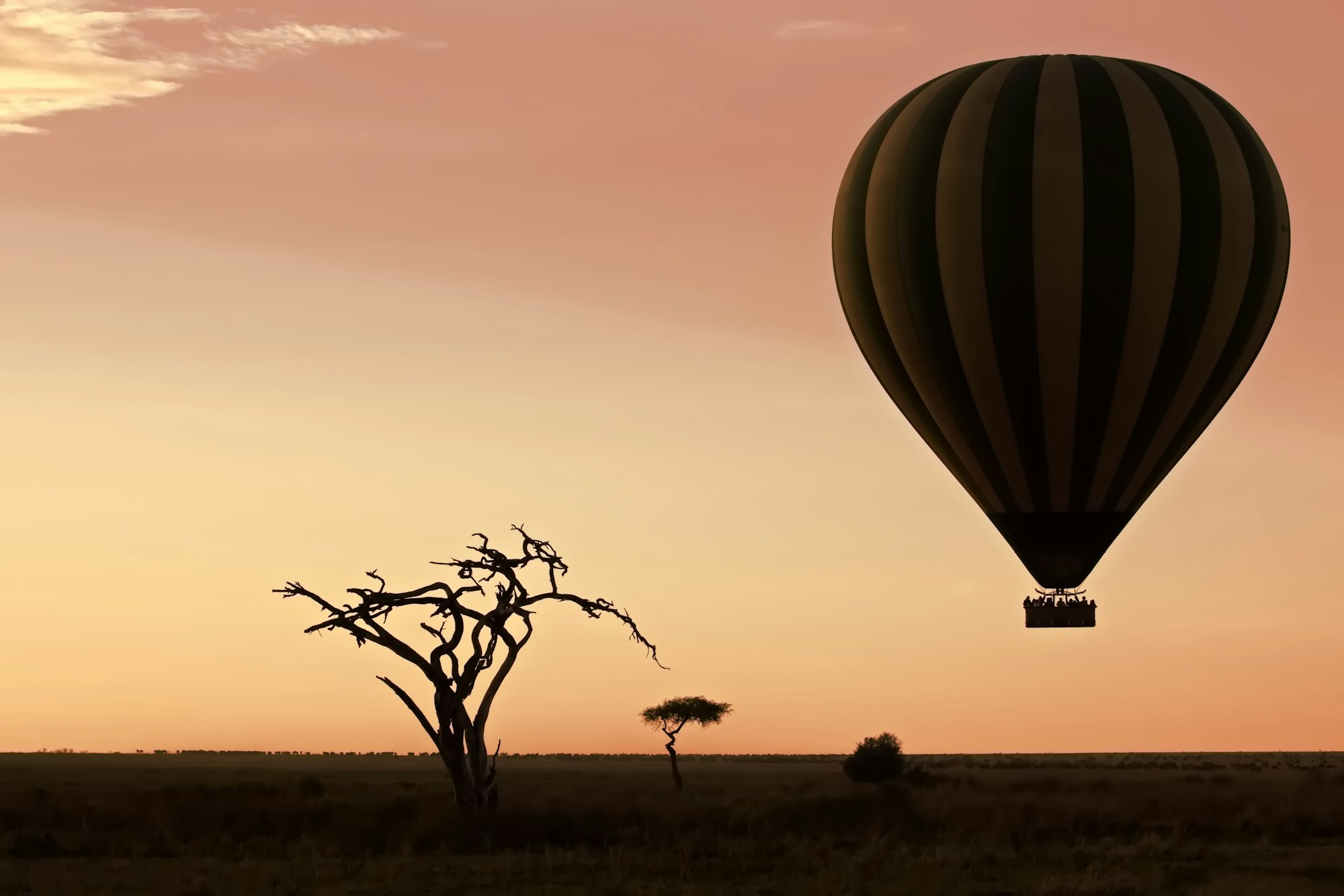 Air balloon flying over a barren landscape at sunset Serengeti, Tanzania